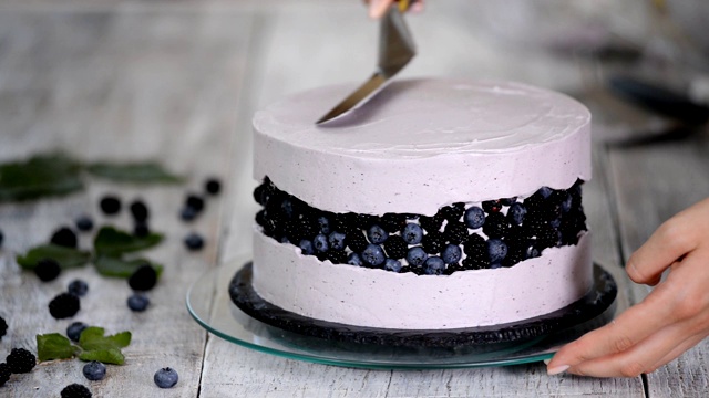 厨房里的糖果师傅用浆果奶油做海绵蛋糕。自制糕点的概念，烹饪蛋糕。视频素材
