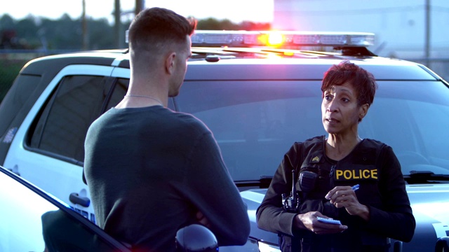 一个女警察在和一个年轻人说话视频素材