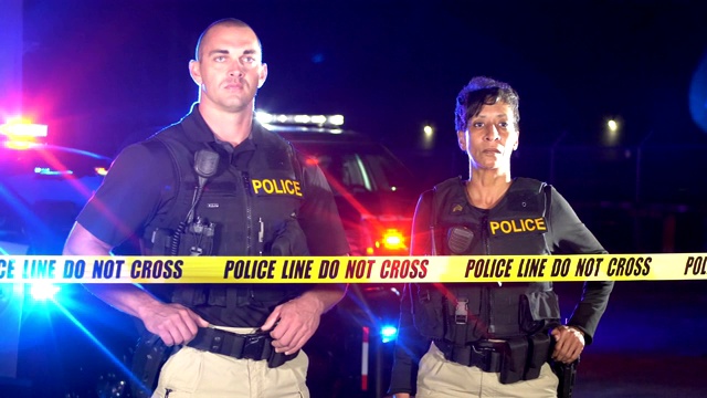 两名警察站在犯罪现场的隔离带后面视频素材