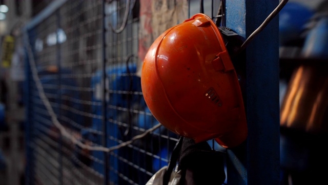 工厂工人橙色头盔的特写。视频下载