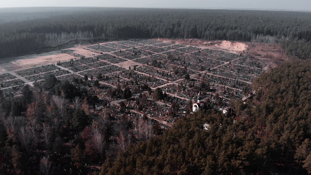 无人机在被森林包围的墓地上空飞行。空中拍摄的墓地。墓地俯视图。无人机在当地村庄墓地上空飞行。视频素材