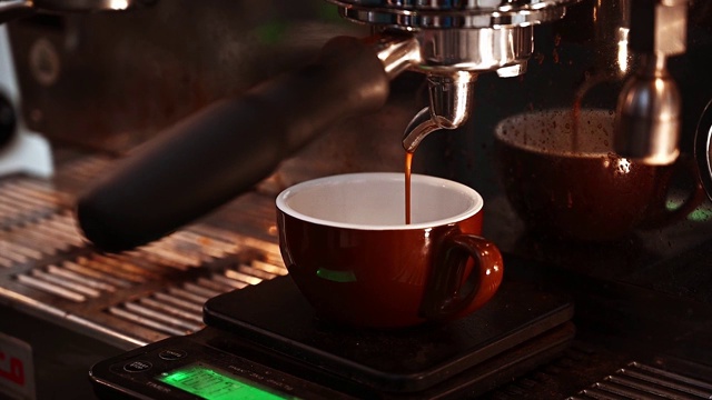 浓缩咖啡从咖啡机倒出来的特写。专业的咖啡酿造。视频素材