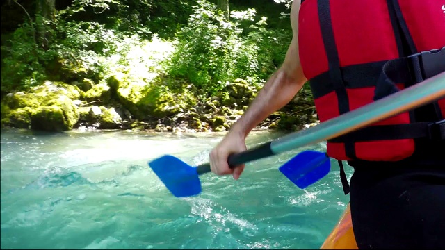 白水漂流队用桨在水中溅起水花，下行汹涌的急流视频素材