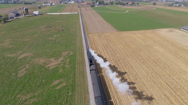 从空中俯瞰，一列蒸汽火车在乡村上空吹着烟和蒸汽视频下载