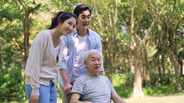 年轻的亚洲夫妇帮助轮椅上的父亲站起来视频素材