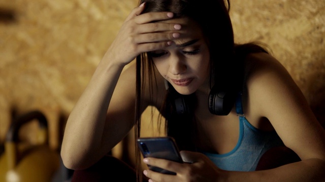 忧心忡忡的女人在健身房用手机视频素材