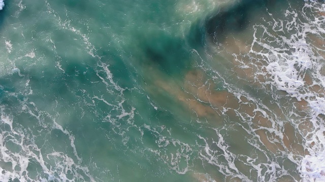 天堂海滩鸟瞰图从上到下拍摄，泡沫的海浪翻滚，来到沙滩上视频素材