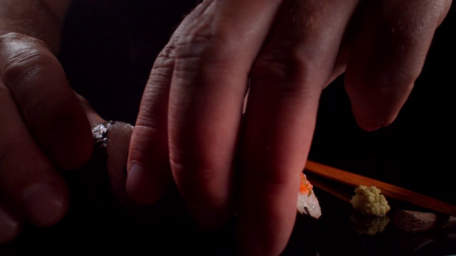 寿司是在一个黑暗的极简主义工作室里用手和筷子端上的视频素材
