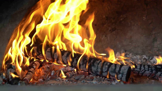 石头壁炉里熊熊燃烧的火焰。在壁炉里烧木柴。燃烧woodlogs视频素材