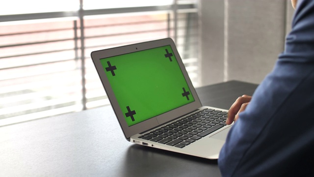 商人的手在笔记本电脑的绿色屏幕上工作视频素材