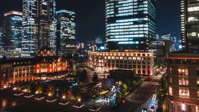 4K延时:缩小夜景的行人旅游人群行走和汽车交通在东京车站附近的市中心火车站，高峰时间视频素材