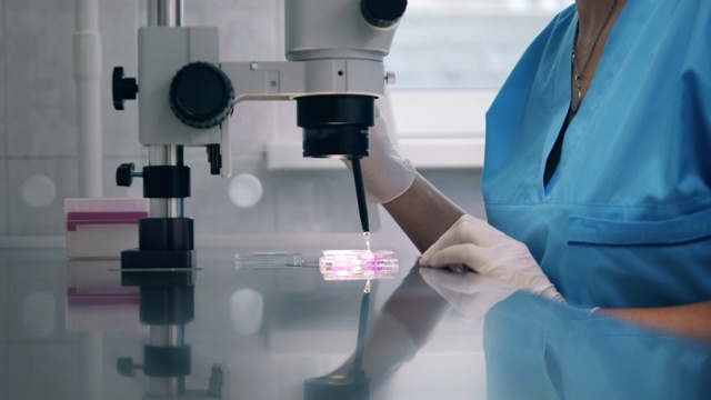 一名妇女使用医疗工具，在医院实验室工作。在科学实验室进行的人工授精。视频素材