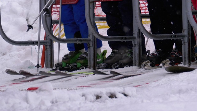 滑雪者通过滑雪缆车的旋转门。滑雪者乘坐的滑雪椅缆车入口。慢动作视频素材