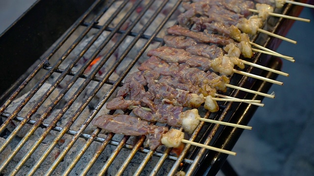 热炭烤架上的烤牛肉加烟，泰国街头小吃。视频素材
