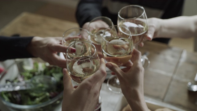 在美国犹他州奥勒姆的餐桌上，人们用葡萄酒敬酒的手的高角度特写视频下载