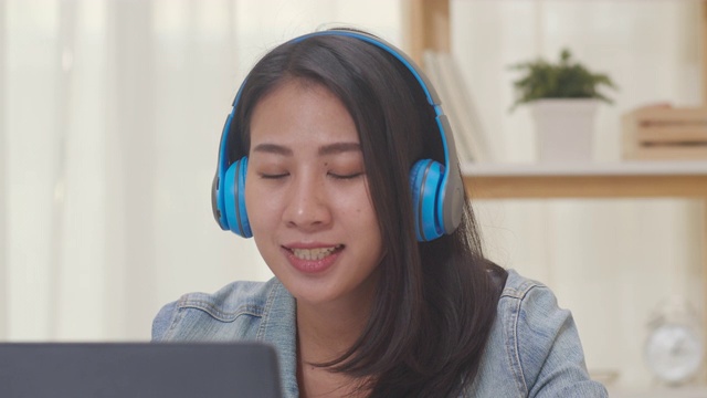 亚洲自由职业商务女性休闲装使用笔记本电脑工作电话视频会议与客户在家里的客厅。视频素材
