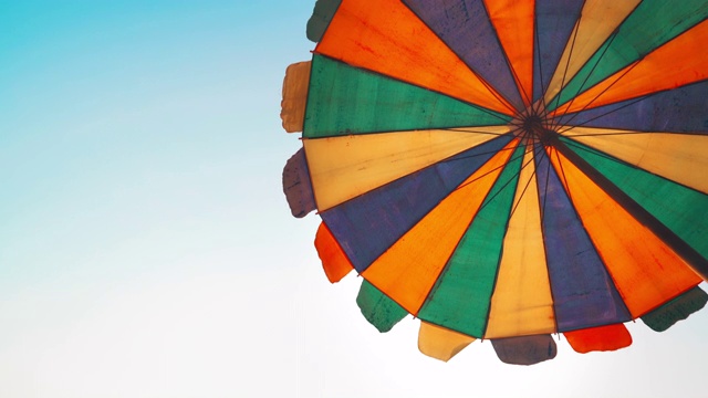 在蓝天背景下的沙滩上的雨伞视频下载