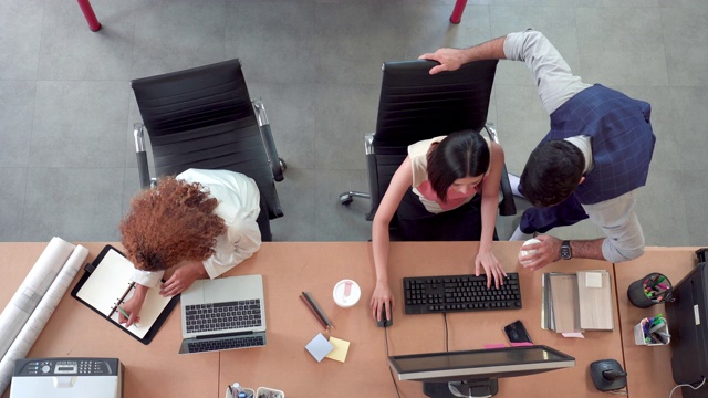 俯视亚洲商业女性和同事在他们的办公桌上工作在办公室视频素材
