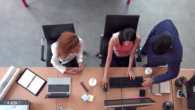 亚洲商业女性和同事通过在办公室与经理击掌来成功地在办公桌上工作视频素材