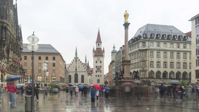 下着雨的德国慕尼黑玛丽恩广场老市政厅，但游客仍带着雨伞观光视频下载