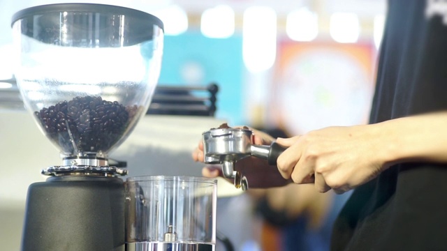 咖啡师为顾客使用咖啡研磨机。视频素材