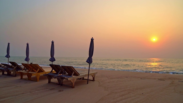 沙滩上的沙滩椅，以大海和天空为背景视频素材