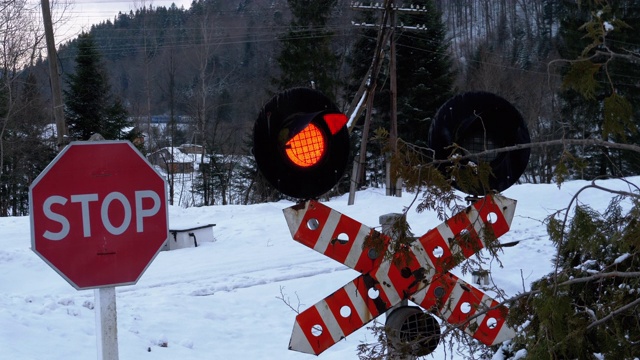 冬天森林里的铁路十字路口红灯闪烁。火车经过视频下载