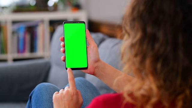 女人在家里使用彩色键屏智能手机视频下载
