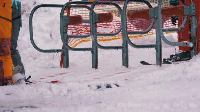 滑雪者通过滑雪缆车的旋转门。滑雪者乘坐的滑雪椅缆车入口。慢动作视频下载
