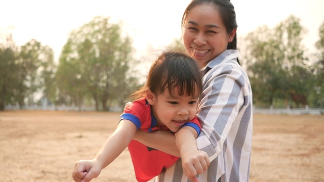 快乐的亚洲母亲和小女儿一起在夏季公园玩。幸福家庭和童年的概念。视频素材