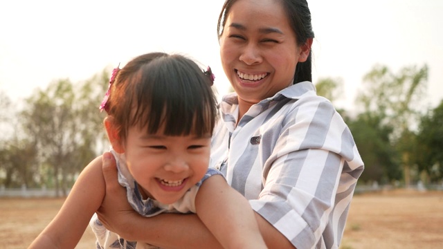 快乐的亚洲母亲和小女儿一起在夏季公园玩。幸福家庭和童年的概念。视频素材