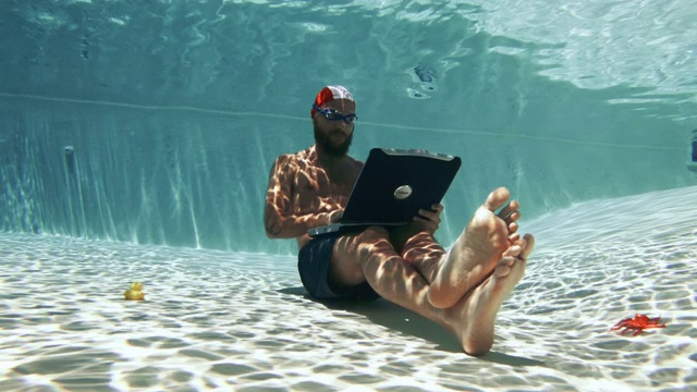 在水下使用笔记本电脑的工作狂:在假期工作视频素材