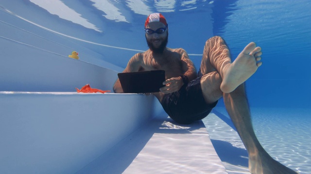 在水下使用笔记本电脑的工作狂:在假期工作视频素材