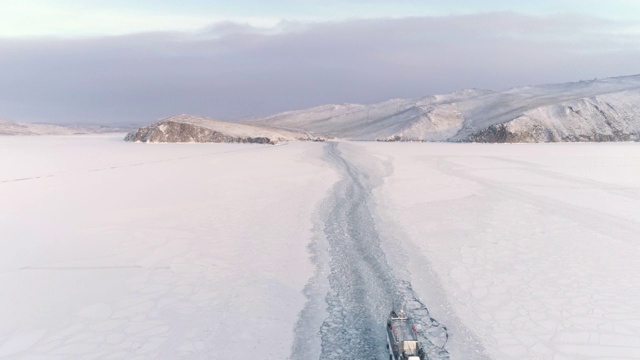 无人机跟踪一艘在冰上移动的破冰船。美丽的冬天的风景视频素材