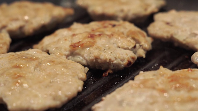 在烤架上炸，油沸，肥肉滴下来。烹饪自制的肉饼视频素材