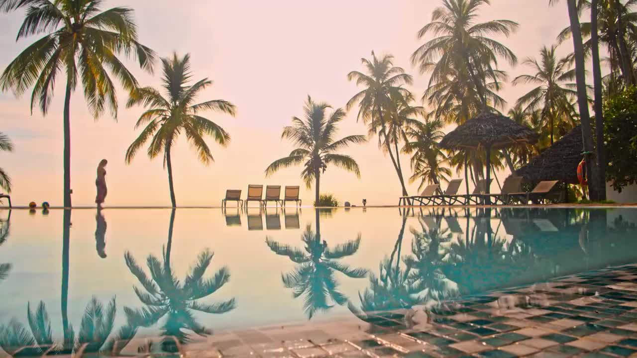 在一个豪华度假胜地的泳池边散步的女人视频下载