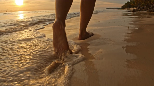 日落时分，一个女人在海滩上散步视频下载