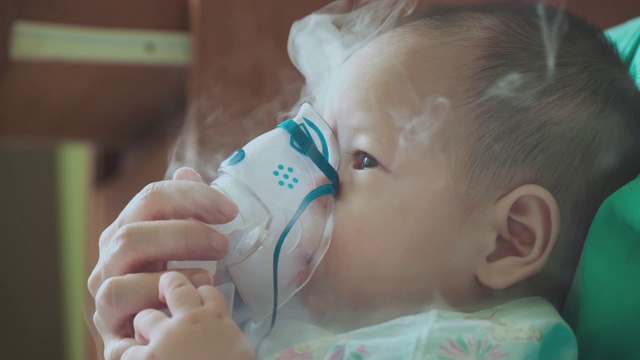 慢动作:用喷雾器治疗生病的婴儿。视频下载
