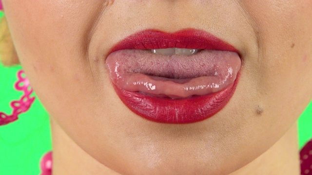 年轻女子红嘴唇，露出舌头做鬼脸。近距离视频下载