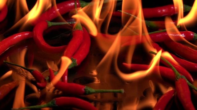 慢镜头:红辣椒滴在燃烧的火焰上视频素材