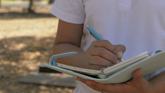 阿曼夏天在公园里散步和写日记。室外工作记录。视频下载