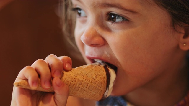 小女孩在吃蛋筒冰淇淋视频素材