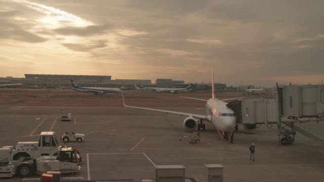 日本东京羽田机场候机楼的一架商业飞机在日落时的慢动作视频素材