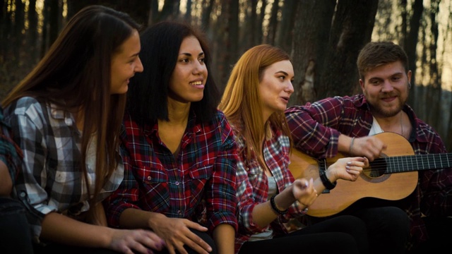 快乐的游客在秋天的森林里弹着吉他唱歌视频素材