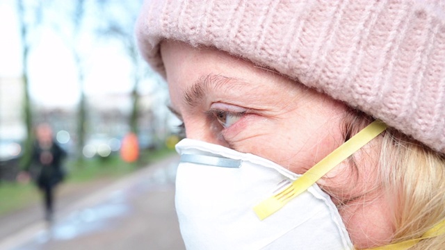 妇女在街道上佩戴防护口罩，既避免感染冠状病毒，又防止传播。在德国柏林的大街上走着一群不认识的人。视频素材