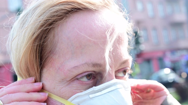 女人在街上戴上保护面具的特写。德国柏林。视频素材