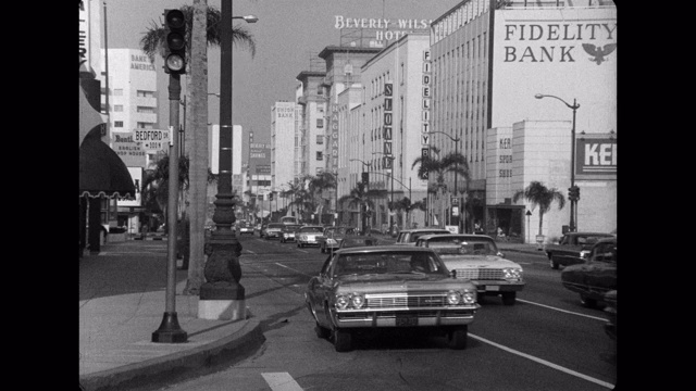 1960年代-车辆行驶在威尔希尔大道，比佛利山，洛杉矶县，美国加州视频素材