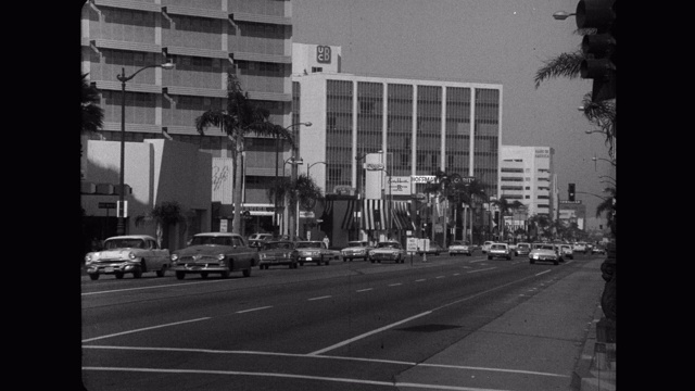 1960年代-汽车行驶在威尔希尔大道，洛杉矶，加利福尼亚，美国的广角镜头视频素材