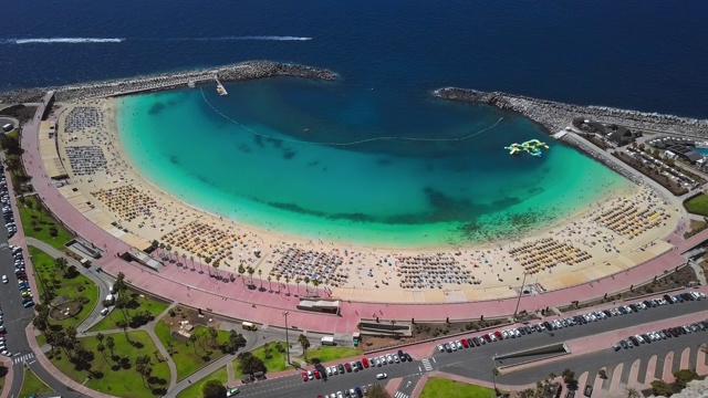 飞过阳光明媚的阿马多雷斯海滩(Playa de Amadores)和蓝绿色的大海，大加那利群岛，加那利群岛，西班牙视频素材
