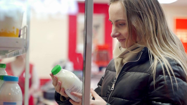 在杂货店挑选牛奶的女人视频素材